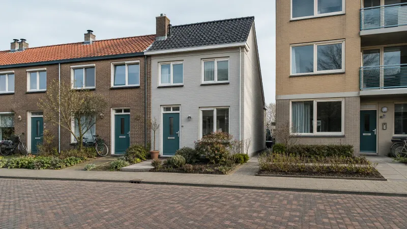 Nederlandse straat met rijtjeshuis, hoekwoning en appartementengebouw, elk met een zichtbaar slot in de voordeur