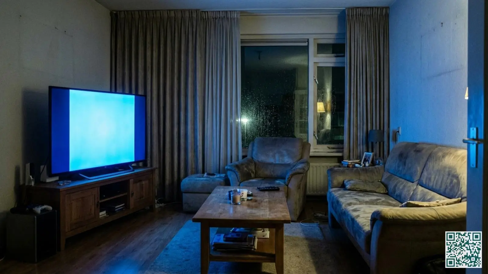 Televisie die blauw licht uitstraalt in een verder lege woonkamer met gesloten gordijnen als misleidende beveiligingsmaatregel