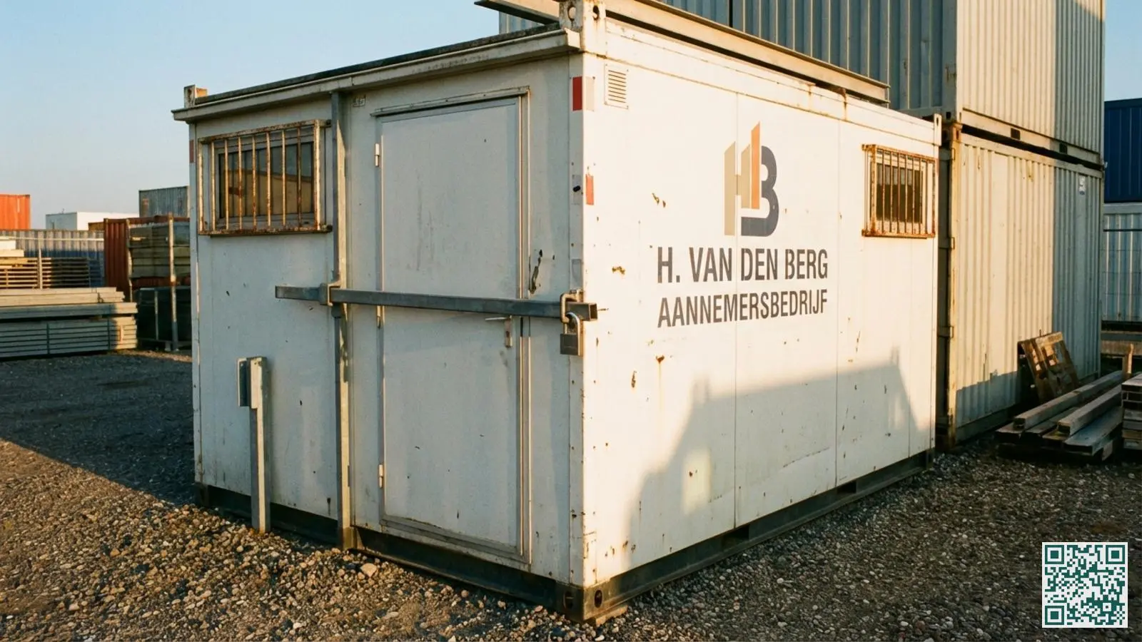 Witte bouwkeet met zwaar containerslot op de deur en beveiligde ramen met metalen tralies op een bouwterrein